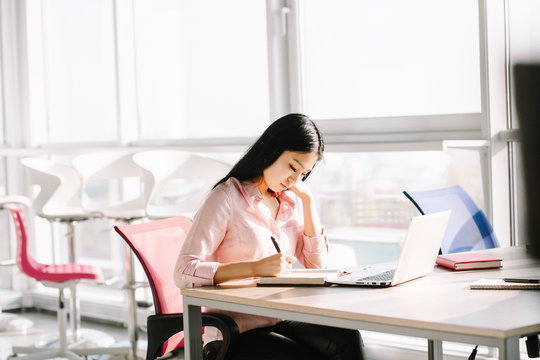 Beautiful manager sitting at desk and working with documents. Office concept.