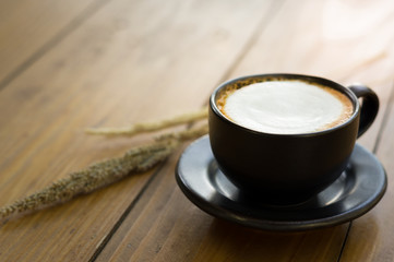 Hot coffee in black cup.