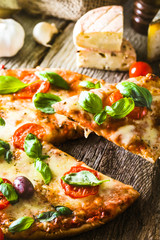 Pizza on wood with ingredients