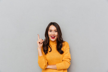 Happy woman in sweater having idea and looking at camera