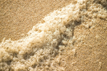 Sandstrand mit Schaum der Brandung