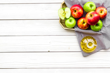 Apple cider vinegar in bottle among fresh apples on white wooden background top view copy space