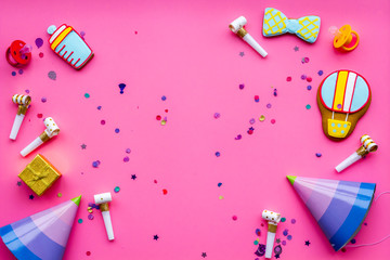 Baby shower. Cookies in shape of accesssories for child, party hats and confetti on pink background top view space for text