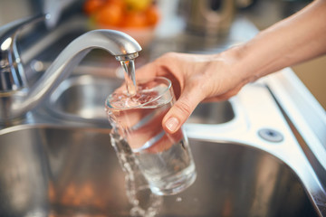 Gießen Sie frisches Leitungswasser in ein Glas