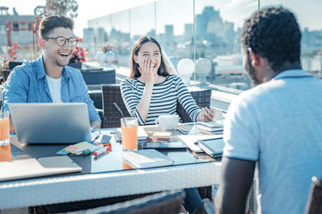 Never bored together. International students cannot keep their emotions inside and beaming with laughter while working on a project together and joking.