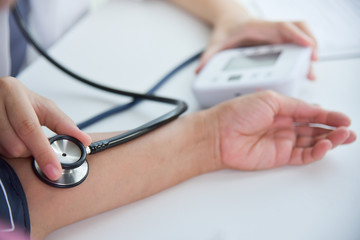 Female doctor measuring blood pressure.