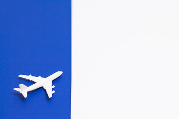 Small white plane on top of blue white background