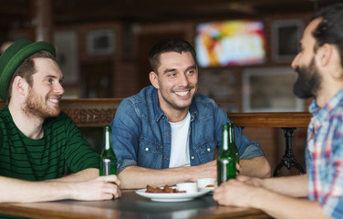 happy male friends drinking beer at bar or pub