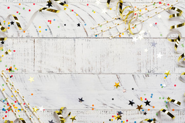 Bright festive carnival background with hats, streamers, confetti and balloons on white background