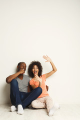 African-american couple looking up, sitting on floor