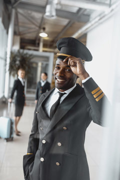 happy young pilot in airport looking at camera