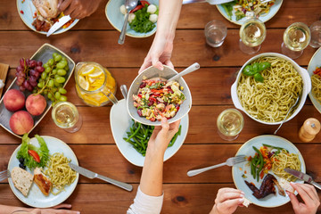 people eating salad at table with food