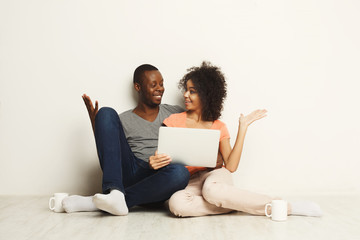 Fototapeta na wymiar Happy african-american couple shopping online on laptop