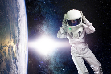 Astronaut in space, in zero gravity near the planet Earth. The concept, find a new earth. Elements of this image furnished by NASA.