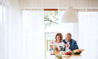 Obraz na płótnie Canvas Senior couple eating breakfast at home.
