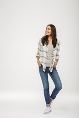 Full length image of Pleased brunette woman in shirt posing