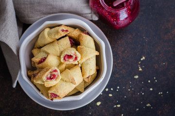 Rugelach (shortbread cookies) with jam filling on stone concrete table background. Copy space, top view