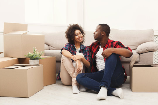 Young balck couple unpacking moving boxes