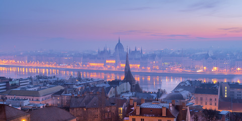 Budapest panorama, Pest riverfront and Parliament building view in morning blue haze across the river