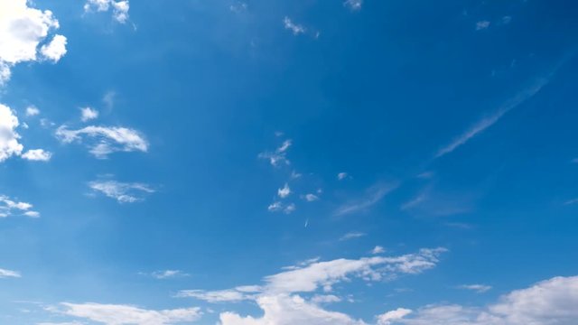 Time-lapse footage of blue sky full of white clouds during a cloudy summer day. White puffy clouds on the blue sky background.
