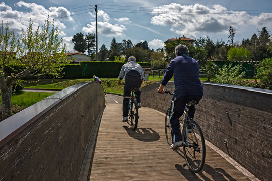 Some cyclists ride the park cycle path on a sunny spring day.
