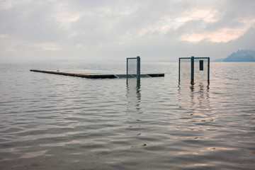 jetty and gates submerged by the waters of the lake, on a winter day