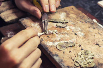 jeweler produces gold jewelry in the workshop