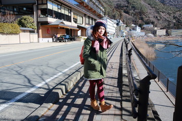 girl wait the bus in bus stop on the roadside