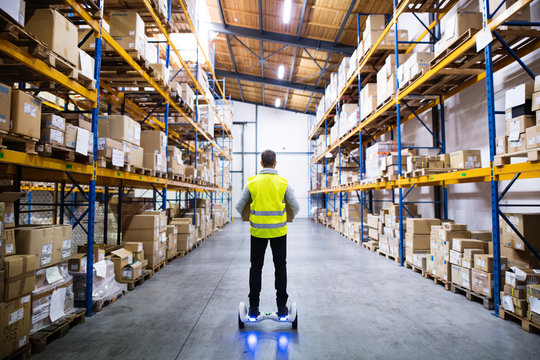 Male warehouse worker on hoverboard.