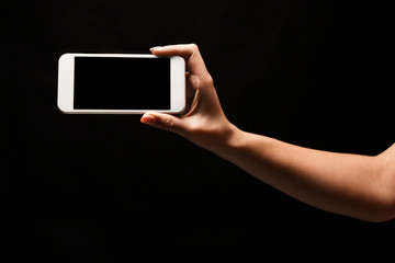 Female hand holding mobile smart phone with blank screen