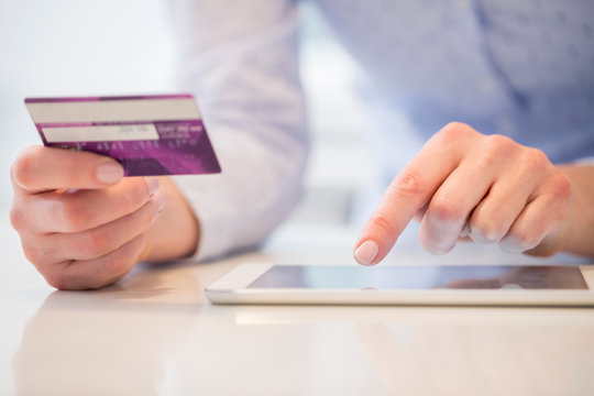 Close Up Of Woman Using Credit Card To Make Purchase On Digital Tablet