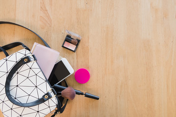 Top view of Women bag and lady stuff with copyspace on wooden background