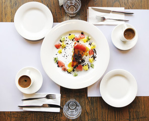 Two cups of coffee and a piece of cake on the table in a cafe