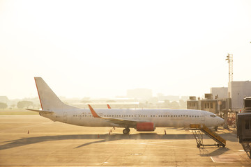 The airplane in airport in morning time ,frelection of sunlight is shining ,vintage warm light tone,blurry light around.