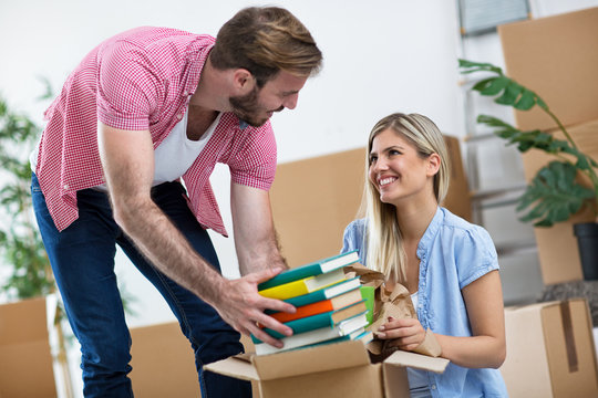 Young couple packs books in the boxes