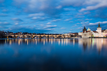 Fototapeta premium Beautiful night view of the Charles Bridge, the Old Town Bridge Tower, and the Old Water Tower, the Smetana Embankment and the Prague Beer Museum in Czech Republic New Year's Eve