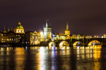Fototapeta na wymiar Beautiful night view of the Charles Bridge, the Old Town Bridge Tower, and the Old Water Tower, the Smetana Embankment and the Prague Beer Museum in Czech Republic New Year's Eve