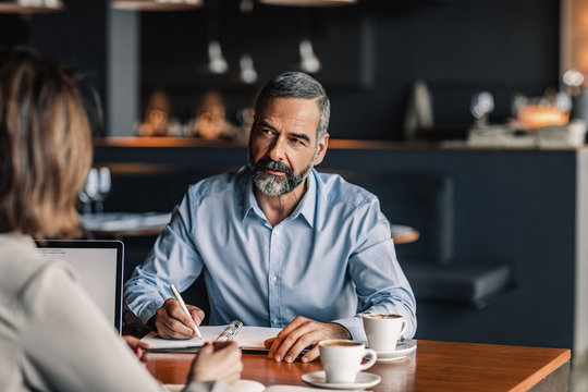 Businessman interviewing woman at coffee shop