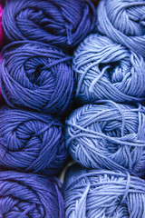 close up of a scale of blue wool yarns sorted by color and storage on a shelf