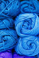 close up of a scale of light blue wool yarns sorted by color and storage on a shelf