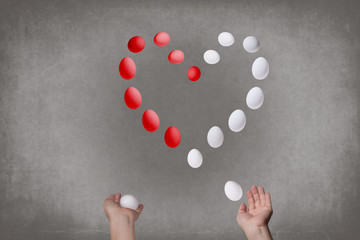 Female hands juggle eggs in the form of Valentine's heart . Food and relations  concept