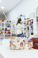 young woman preparing a workshop to do it yourself a scarf with woolen yarns