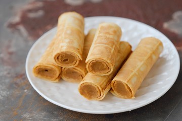 Delicious waffles with condensed milk in the dish 