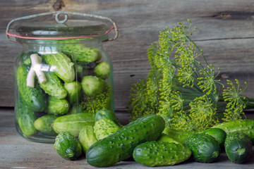 Jars of pickled marinated cucumbers on rustic table