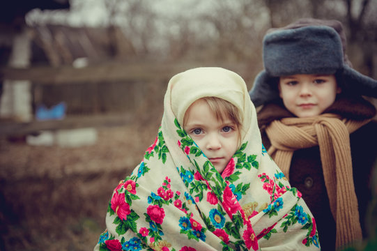 Rural children in old clothes - scarf, coat, hat