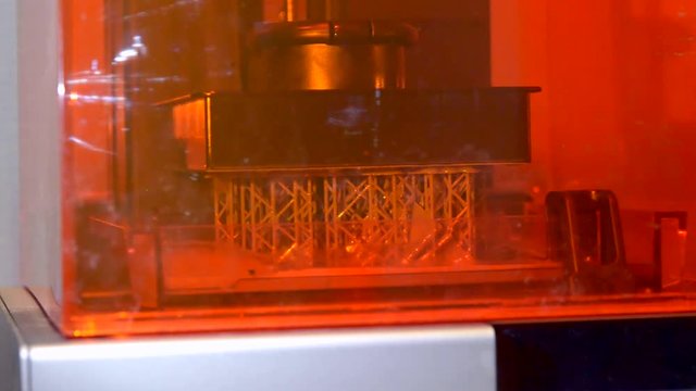 Stereolithography DPL SLA 3d printer create and liquid drips, platform slowly move with liquid close-up. Progressive modern additive technology 3D printing, create scaled model by UV polymerization