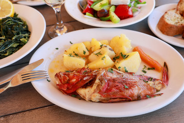 Cooked fresh red scorpionfish sarved with boiled potatoes in the greek tavern.