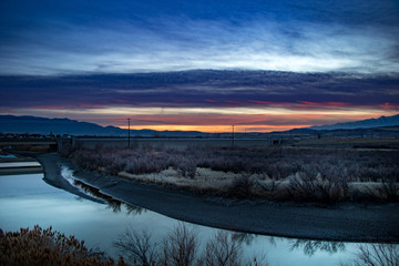 Stunning sunset beyond the river and mountains