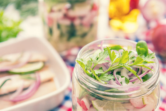 Salads with vegetables and sliced herring fillets