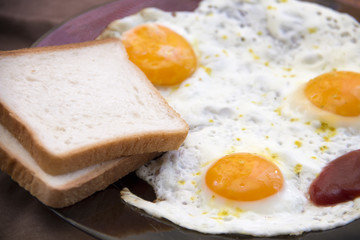 English breakfast, fried eggs with toast on an old textured table